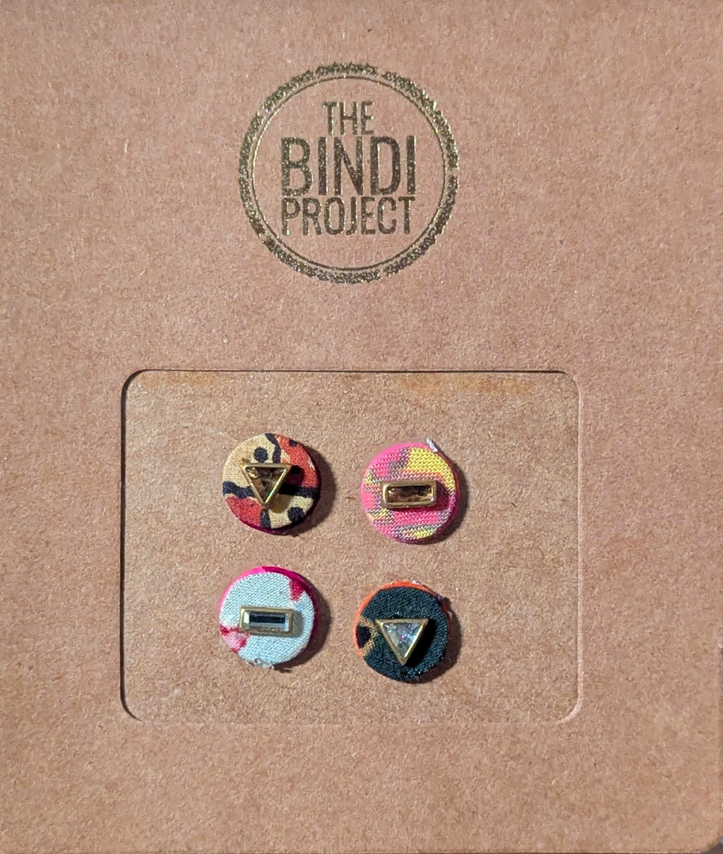 Set of four 14mm round textile bindis with colorful geometric and abstract designs on brown card backing.