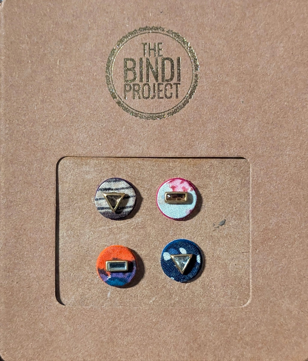 Set of four 14mm round textile bindis with geometric and floral motifs in neutral, pink, orange, and navy colors on kraft.