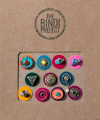 Colorful 12mm decorative bindis in various geometric and floral designs on a brown backing card.
