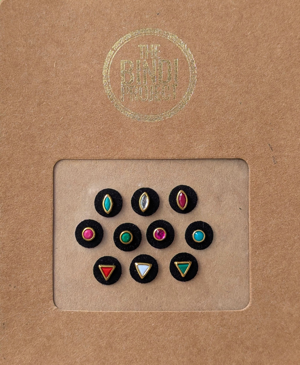 Set of 10 black circular bindis with colorful geometric and teardrop designs in maroon, red, blue, and green.
