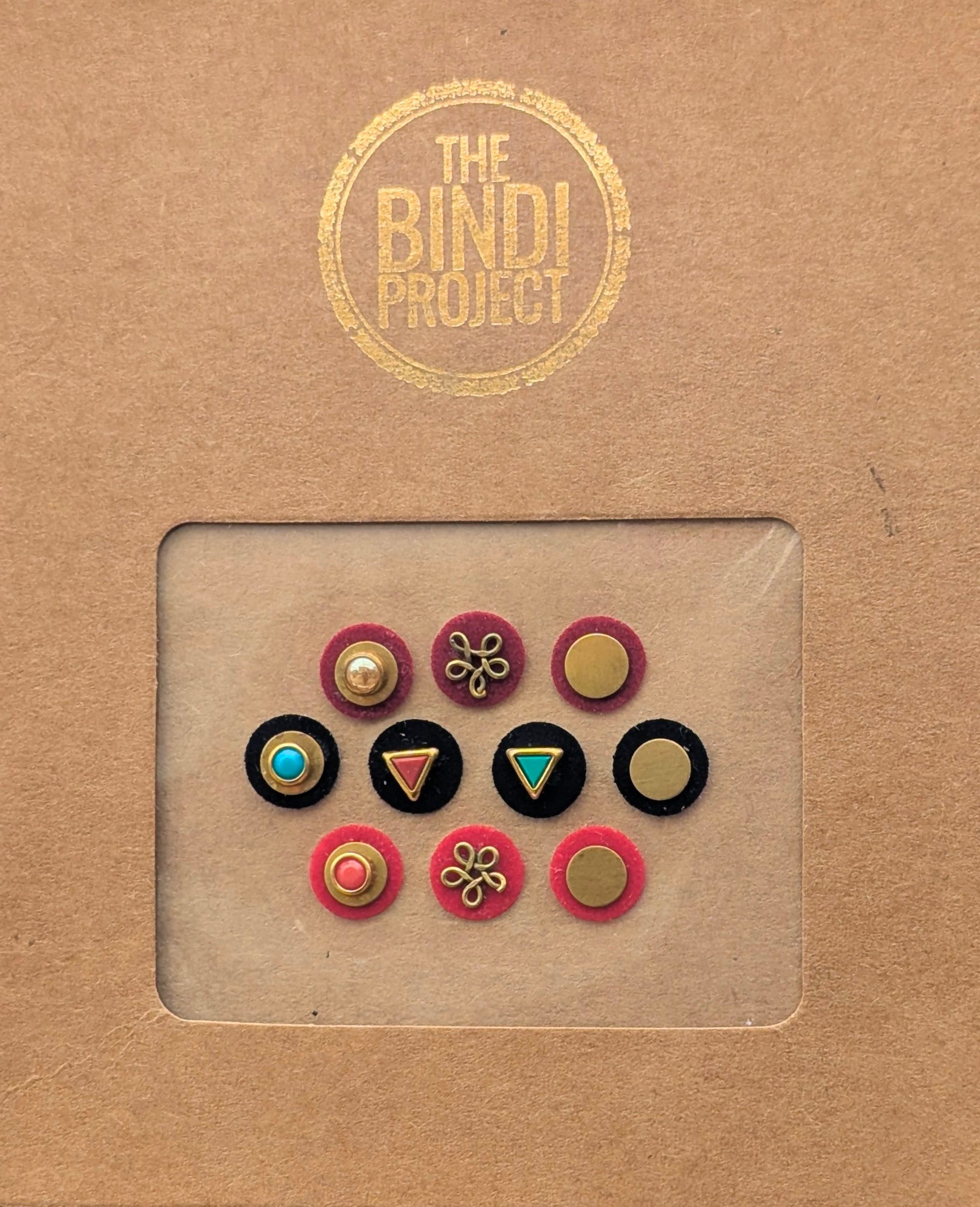 Set of 10 small round 10mm statement bindis in pink, black, and blue with gold accents and decorative designs.