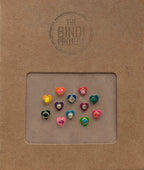 Set of 12 small multicolor stone bindis in heart shapes on a brown textured card.