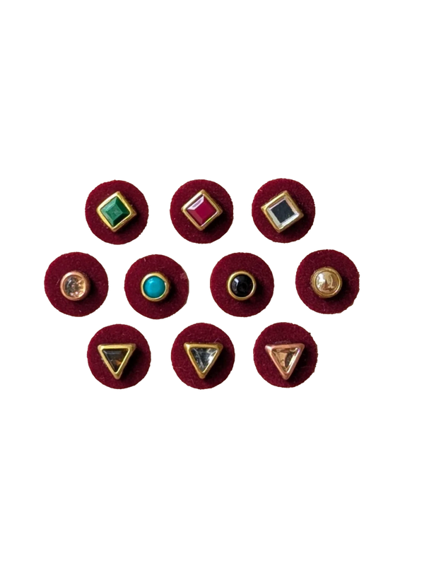 Set of 10 maroon 10mm bindis with assorted geometric brass designs and colorful center stones.